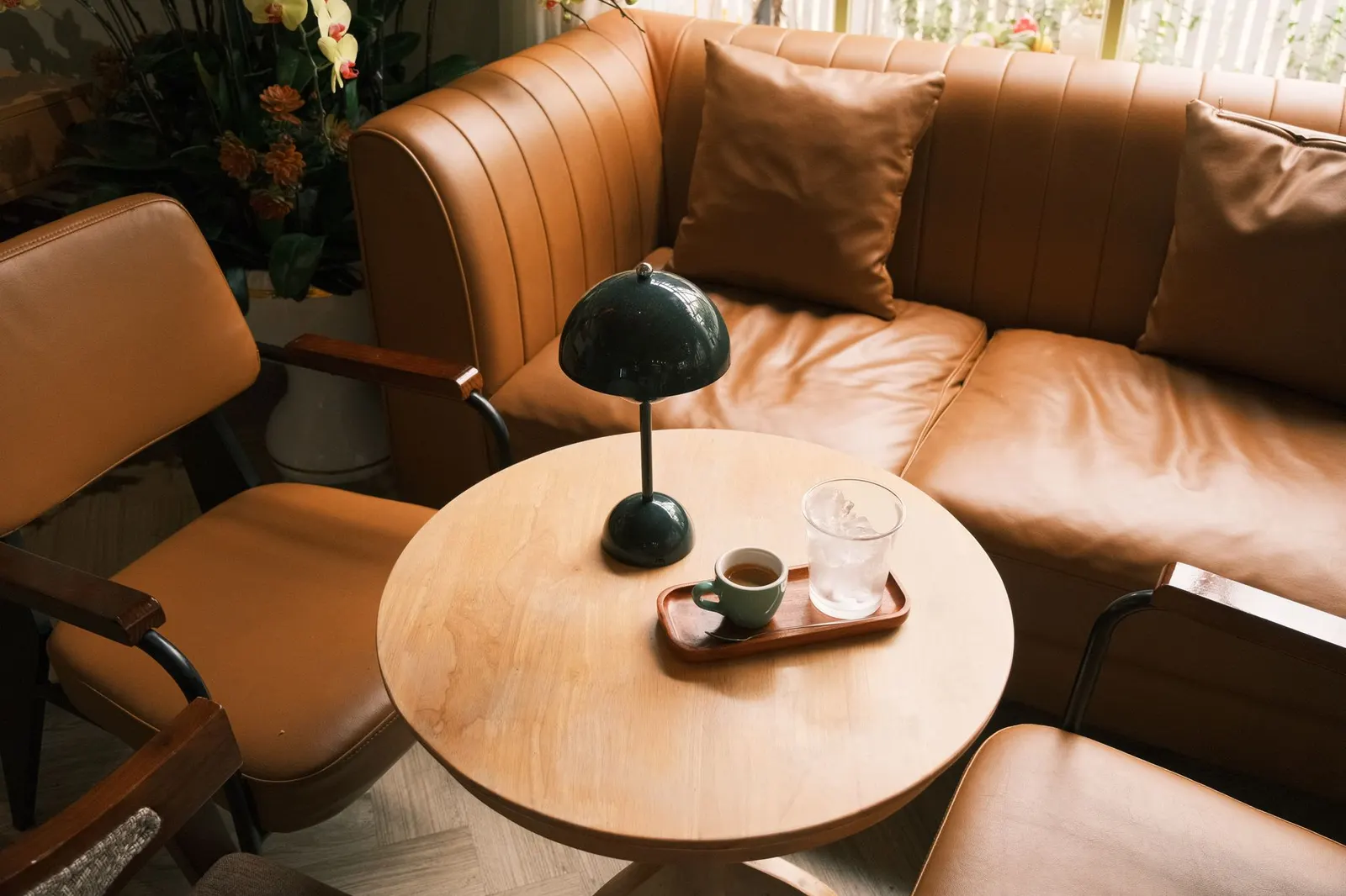 A warm living room scene with leather armchairs, a coffee table, and a stylish lamp.