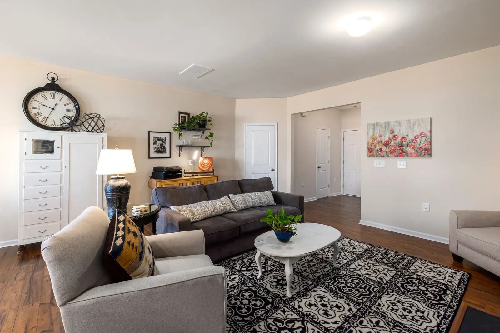 Living room with an 8 x 10 jute rug under the front legs of a gray sofa and two armchairs