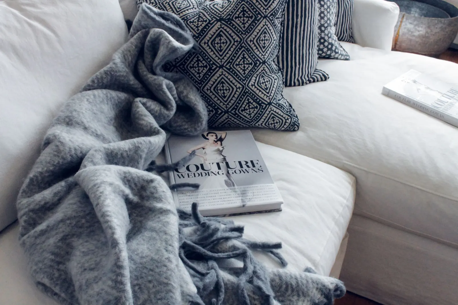 Living room in winter with lined curtains, a wool rug, a knit throw on the sofa and snow outside