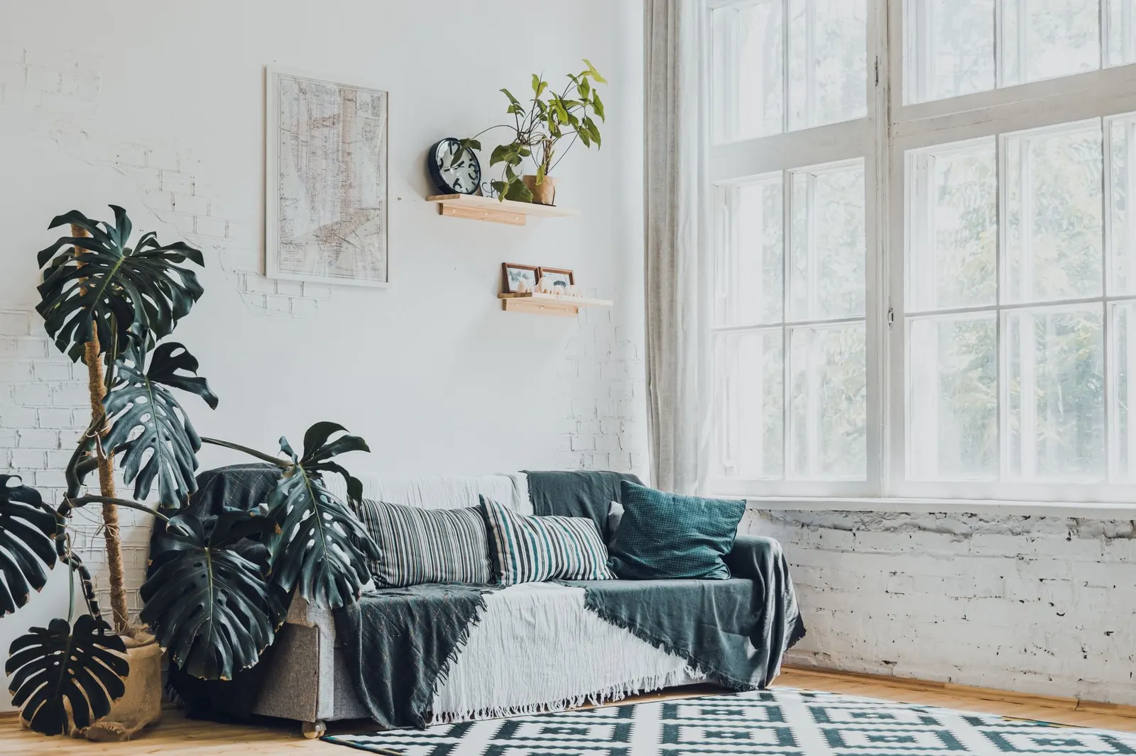 Bright living room with linen curtains, a washable flat-weave rug, potted plants and a ceiling fan