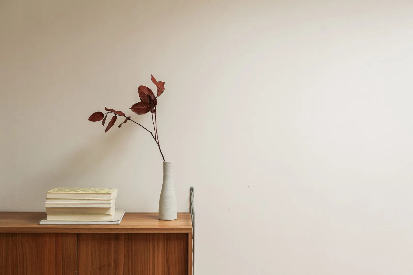 Matte stone-look vases, a gold mirror tray and candle holders styled on a wood console table