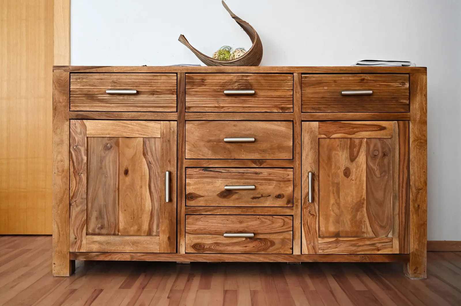 Solid wood cabinet with a row of drawers above two paneled doors