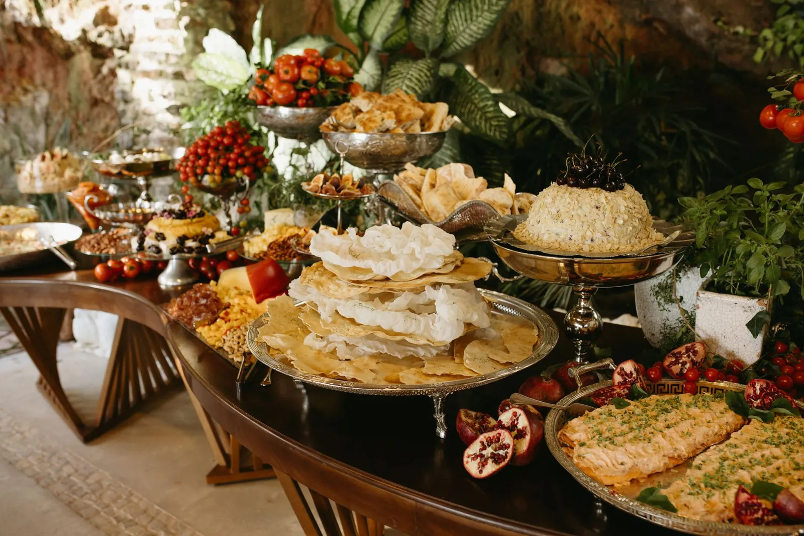 Kitchen counter buffet with labeled potluck dishes, stacked plates and napkins