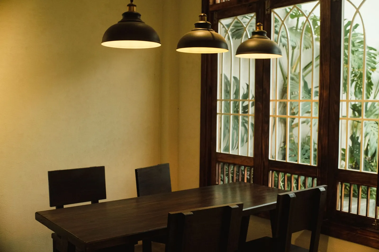 Elegant dining area in Dalat, Vietnam featuring wood table, chairs, and pendant lights.