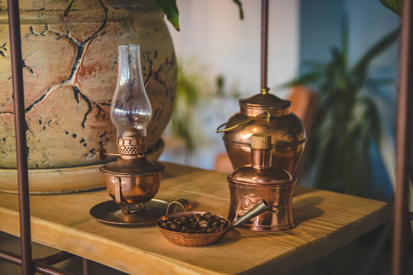 Brass and copper oil lamp and vintage pieces on a wooden shelf