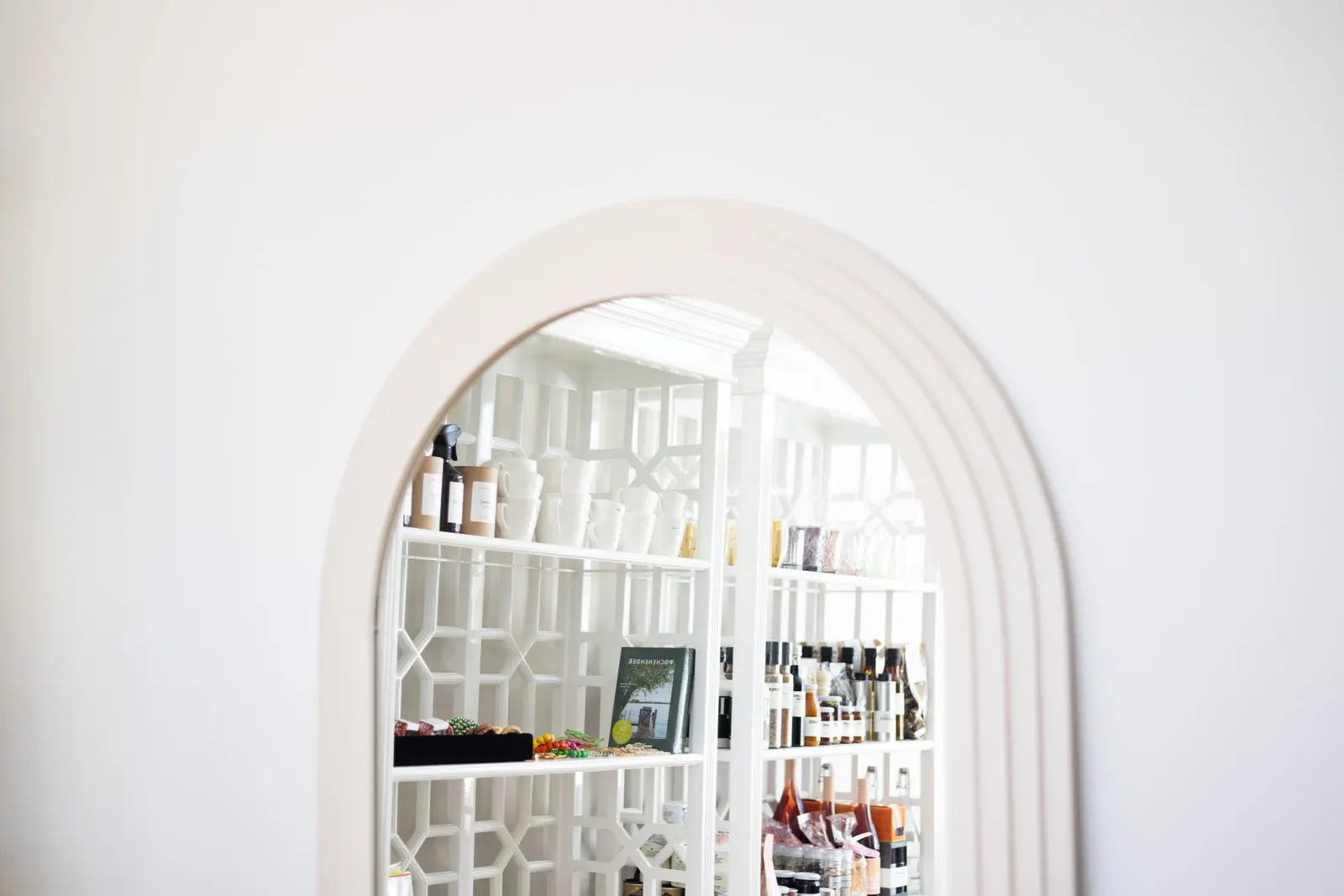 Stylish minimalist interior featuring an arched doorway and modern white shelves.